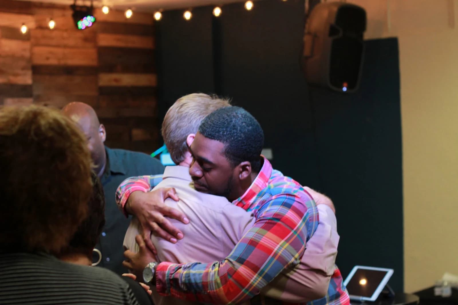 Two people sharing an encouraging moment during a Living Message Church gathering.